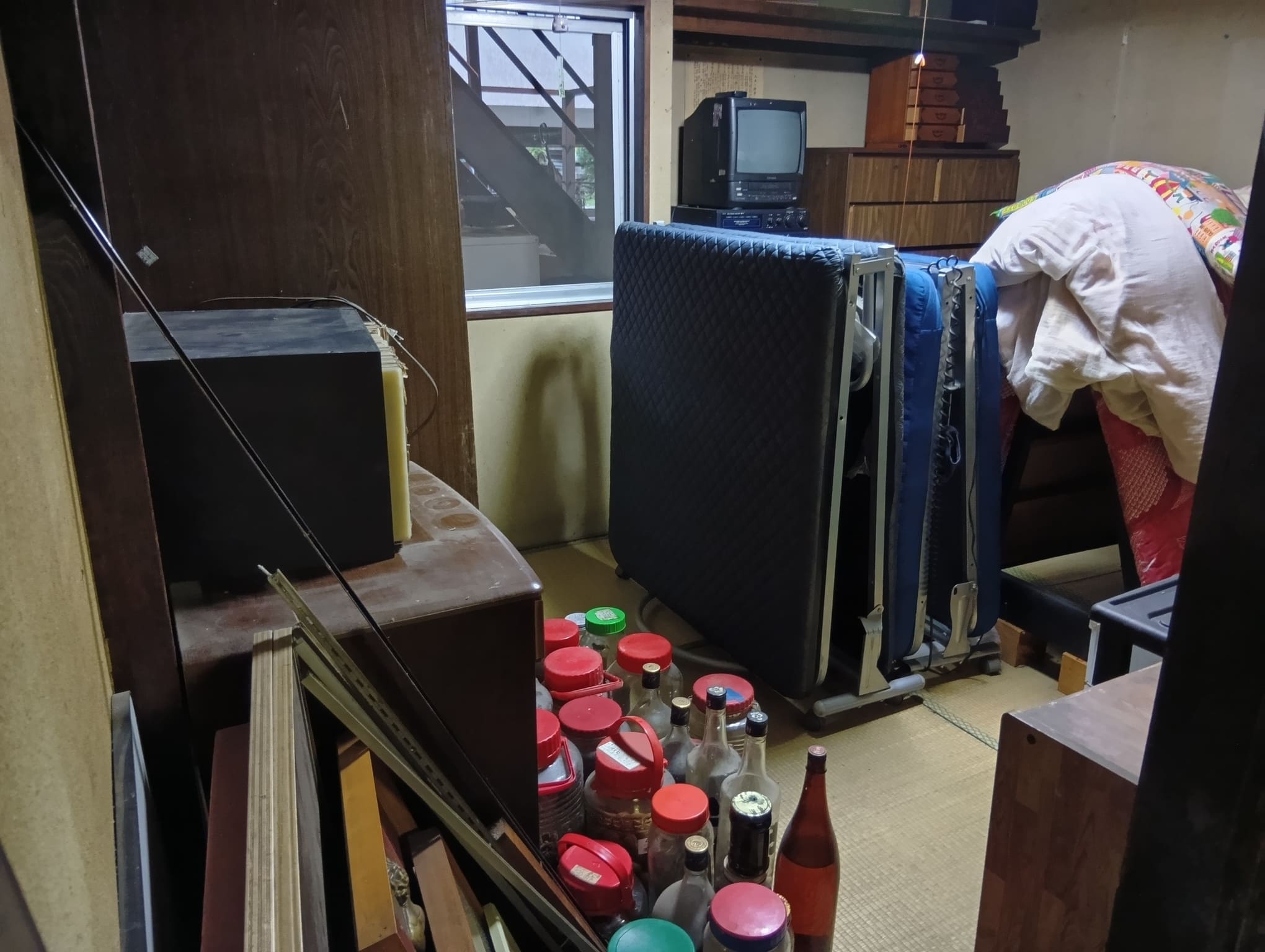 辰野町、片付け前の不用品が積まれた部屋の様子